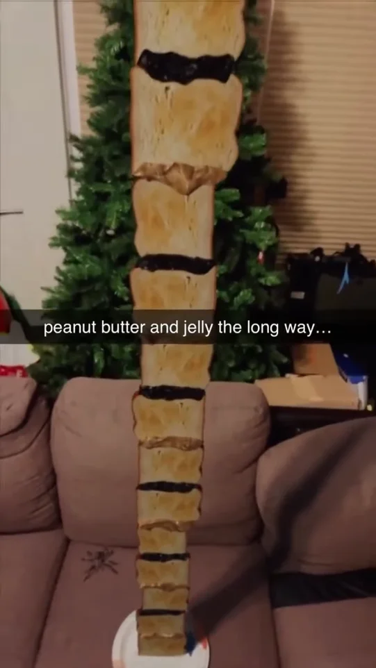 peanut butter and jelly the long way, bread is stacked vertically crust to crust with peanut butter and jelly connedting the building a tower